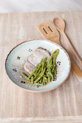 Chicken breast with green peas in rustic plate