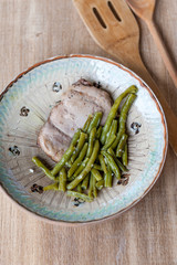 Chicken breast with green peas in rustic plate