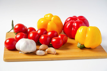 Tomatoes, garlic and pepper on the Board, white background
