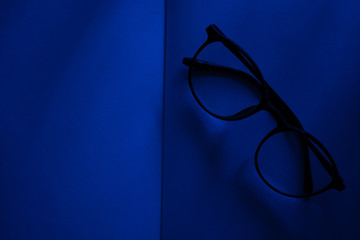 white blank book with Glasses at blue room night