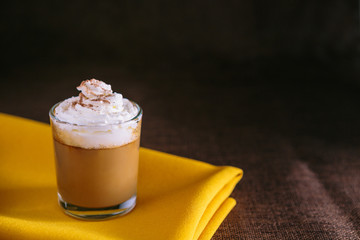 Mini cappuccino presented in a small glass. On black background