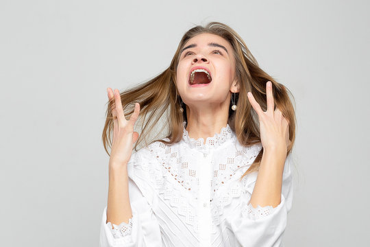 Very angry woman. Frustration. Frustrated and stressed young businesswoman. Beautiful young mixed race asian / caucasian woman isolated on white background.