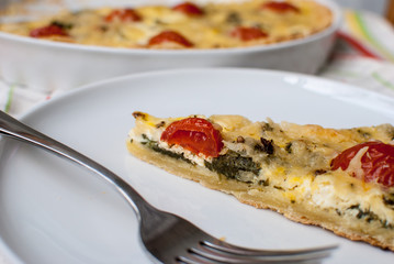 A slice of Loren quiche on a plate with fork