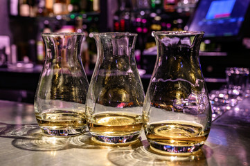 Obraz na płótnie Canvas Flight of Scottish whisky, tasting glasses with variety of single malts or blended whiskey spirits on distillery tour in pub in Scotland