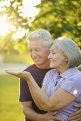 Fototapeta premium Portrait of senior couple in the park showing something