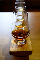 Flight of Scottish whisky, tasting glasses with variety of single malts or blended whiskey spirits on distillery tour in Scotland