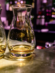 Flight of Scottish whisky, tasting glasses with variety of single malts or blended whiskey spirits on distillery tour in pub in Scotland