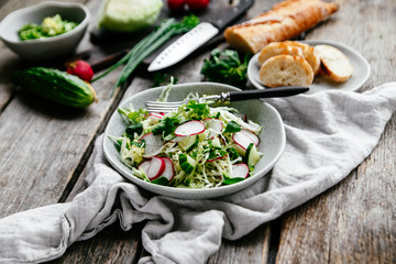 Salad with young cabbage, radish and cucumbers. Vegetarian salad