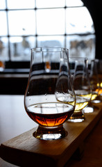 Flight of Scottish whisky, tasting glasses with variety of single malts or blended whiskey spirits on distillery tour in Scotland