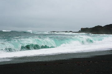 Raging sea in a black and turquoise landscape