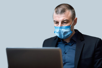 Businessman Working On Laptop Wearing Medical Mask Sitting In Studio