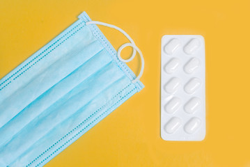 Blue medical mask n95. Tablets in blister on an orange background