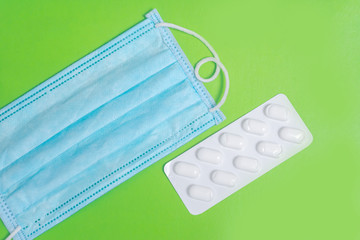 Medical mask n95. Tablets in a blister. Green background