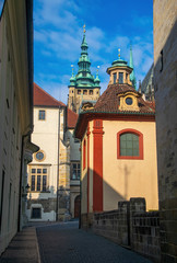 Empty narrow street in Prague castle. Chapel of John of Nepomuk and tower of St. Vitus Cathedral on background, Prague