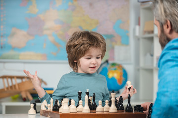 Happy child and childhood. Boy kid playing chess at home. Concentrated boy developing chess strategy, playing board game. Little boy with chess.