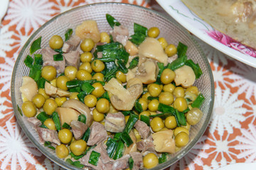 homemade salad of herring, mushrooms, green peas and leek close-up   