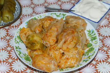 plate on a table with a dish of, Moldavian cabbage rolls with a plate of sour cream closeup  
