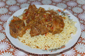 plate on the table with a dish of couscous   with goat meat 