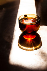 A large cup of tea casts a curly shadow on the table