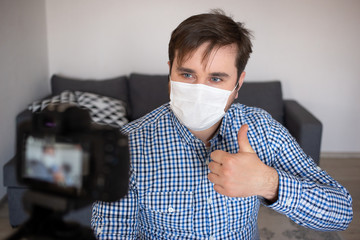 blogging, videoblog and people concept - camera recording video blog of male blogger at home