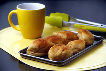 Popular Filipino bread called Pandesal or Salt bread and a coffee mug on a table