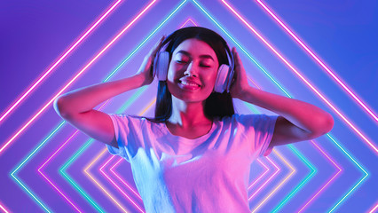 Girl listening music on headphones and closed eyes