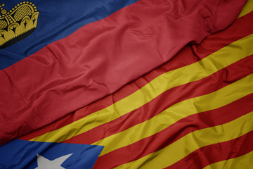 waving colorful flag of catalonia and national flag of liechtenstein.