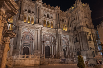 Fototapeta na wymiar Malaga Cathedral facade exterior at night front western entrance illuminated.