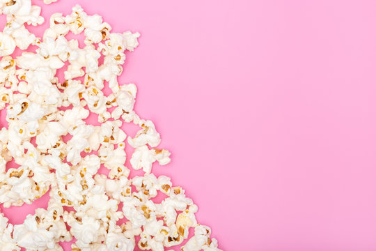 Popcorn on pink background. Movie or TV background, border, frame. Top view Copy space