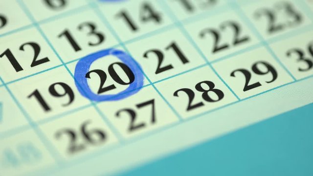 Marking the date in the calendar with a blue marker. The twentieth day of the month