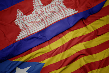 waving colorful flag of catalonia and national flag of cambodia.
