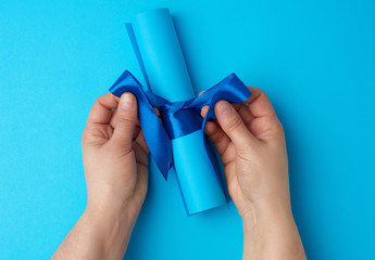 roll of blue paper tied with a silk blue ribbon