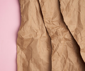 background of layered brown torn paper with a shadow on a pink background