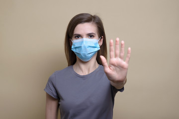 Protection against contagious disease, coronavirus. Woman wearing hygienic mask to prevent infection, airborne respiratory illness such as flu, 2019-nCoV. Studio shot isolated on .beige backgroun
