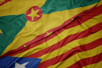 waving colorful flag of catalonia and national flag of grenada.