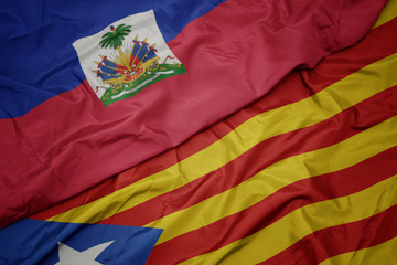 waving colorful flag of catalonia and national flag of haiti.