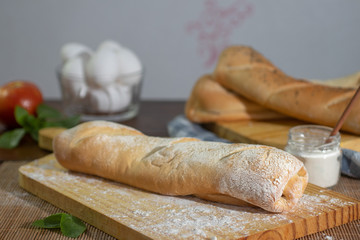 Fresh french baguettes made from white flour on wooden table.