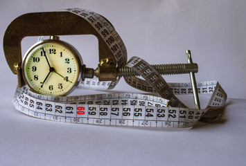 Measuring device, watch and ribbon on a white background.