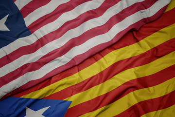 Obraz premium waving colorful flag of catalonia and national flag of liberia.