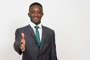 Portrait of happy young African businessman in suit giving handshake
