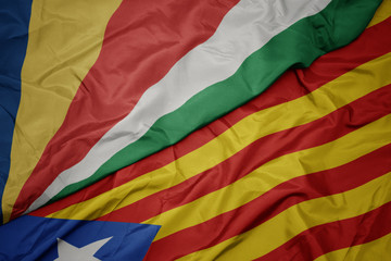 waving colorful flag of catalonia and national flag of seychelles.