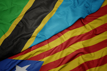 waving colorful flag of catalonia and national flag of tanzania.
