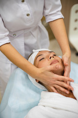 Obraz na płótnie Canvas young woman during cosmetological procedure of face massage