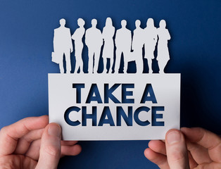 Hands holding a take a chance white card business team people sign