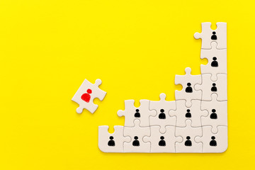 image of puzzle pieces with people icons over yellow background ,human resources social distancing and management concept