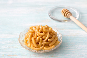 Chak chak, pieces of dough in honey, tatar traditional dessert on light blue background