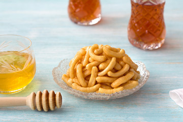 Chak chak, pieces of fried dough in honey, tatar traditional dessert on light blue background
