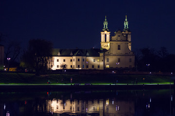Fototapeta na wymiar View from the Grunwaldzki bridge on church near Vistula river at night. Selective focus, long exposure