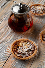 Close up of a nuts gluten free tartlet with honey, almonds and walnut with black tea