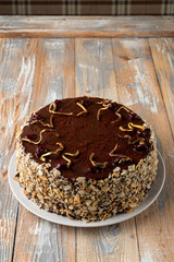 Chocolate and cherry torte with almond flakes and golden chocolate decoration